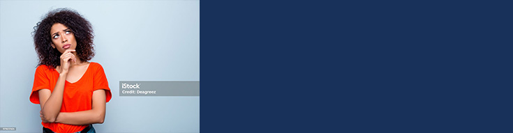 Woman signing a form at a reception desk while a smiling receptionist in scrubs assists her.